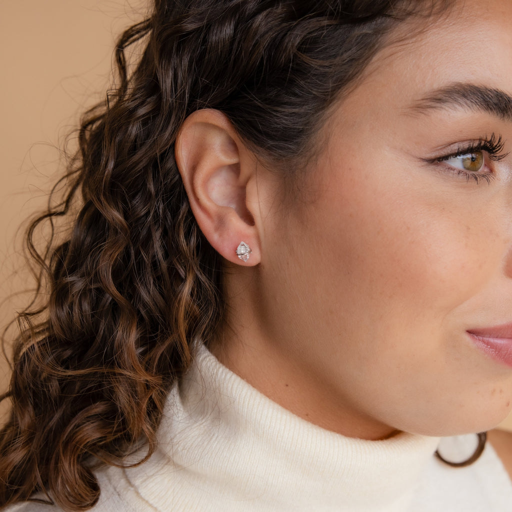 Close-up of a woman with curly hair wearing Herkimer Diamond Studs and a cream turtleneck sweater.