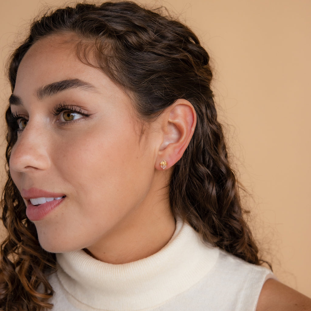 Woman with curly hair wearing a cream turtleneck and the Herkimer Diamond Studs, looking to the side.