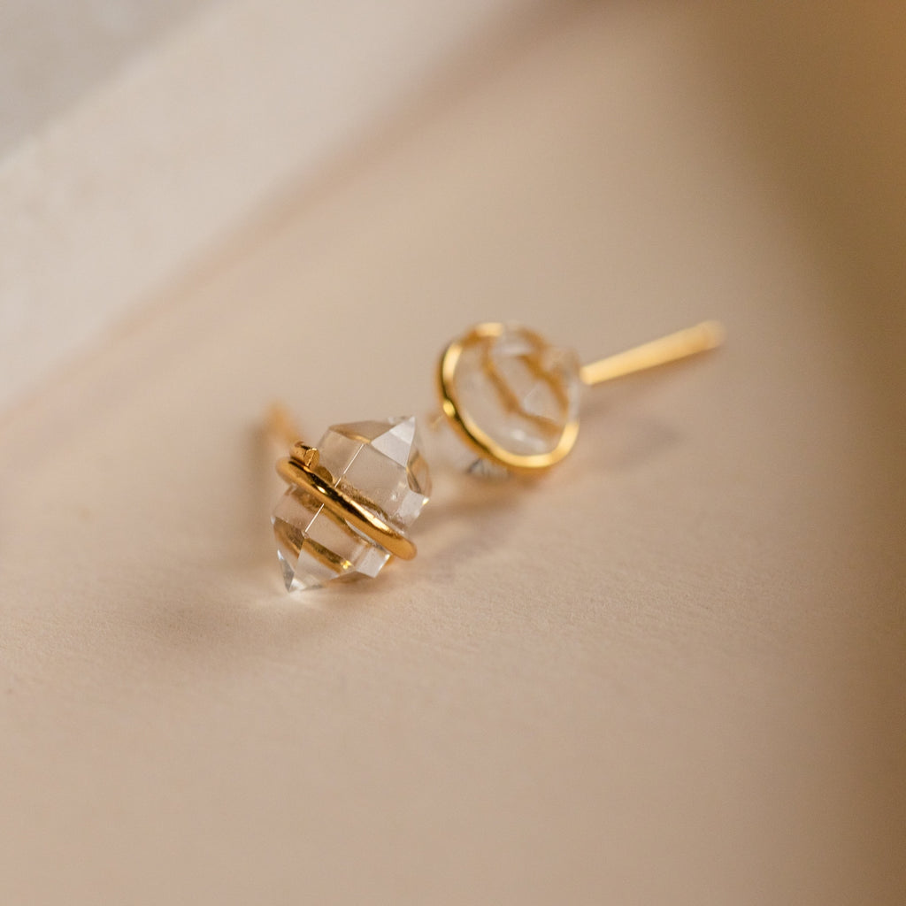 The Herkimer Diamond Studs are minimalist gold stud earrings with a clear stone, adding effortless elegance to any look.