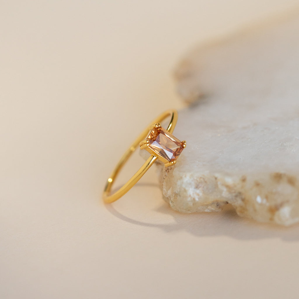 The Citrine Emerald Ring features an elegant gold band and a square emerald-cut citrine stone—an ideal choice for anyone with a November birthstone.