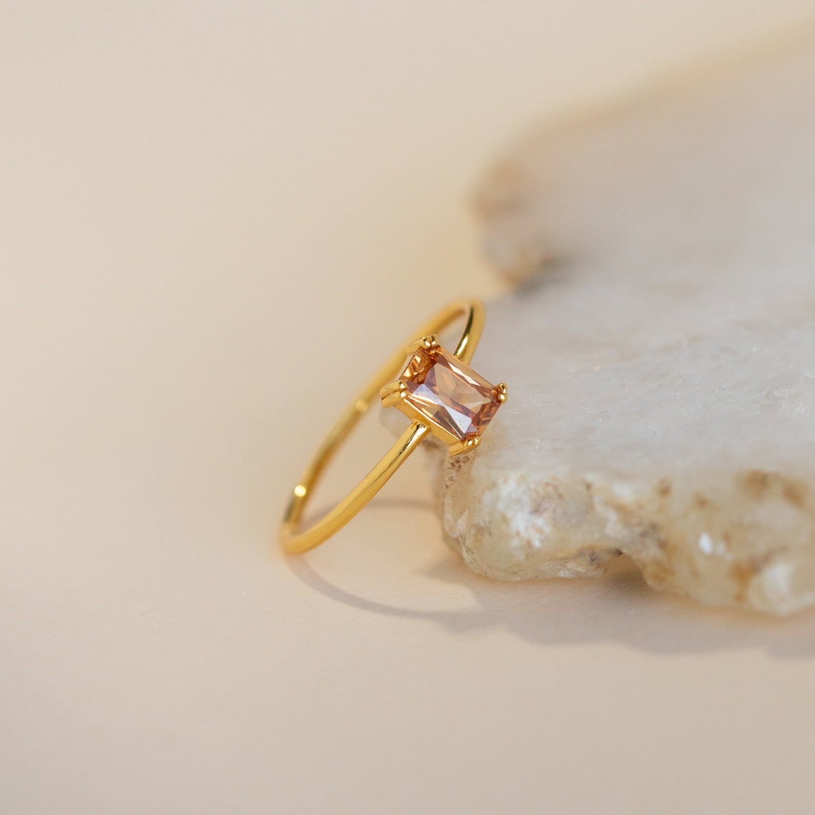 The Citrine Emerald Ring features an elegant gold band and a square emerald-cut citrine stone—an ideal choice for anyone with a November birthstone.