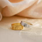 3D Name Band rings in sterling silver and gold with bold 3D custom engraved names EMILY and LIAM visible.