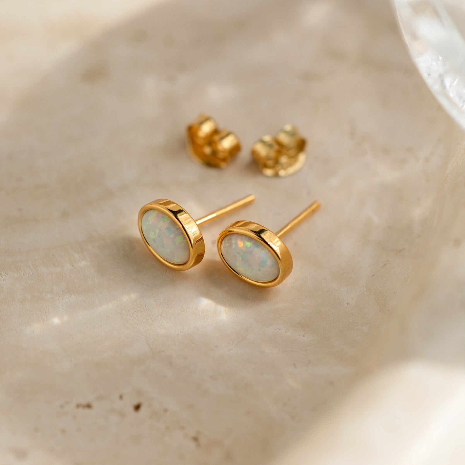 Oval Opal Studs: Elegant stud earrings featuring white opal stones set in gold.