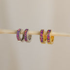 Lavender Opal Inlay Huggies, minimalist hoop earrings with a subtle purple opal shimmer, are displayed together on a stick.