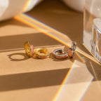 Pink Opal Inlay Huggies are beautifully displayed on a table.