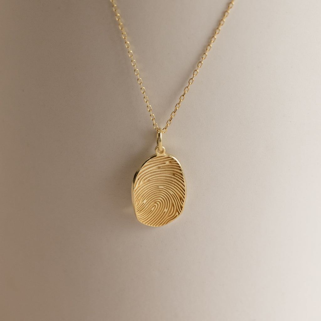 Custom Fingerprint Necklace in Rose Gold featuring an oval pendant engraved with a unique fingerprint, shown on a neutral background—an ideal sentimental gift.