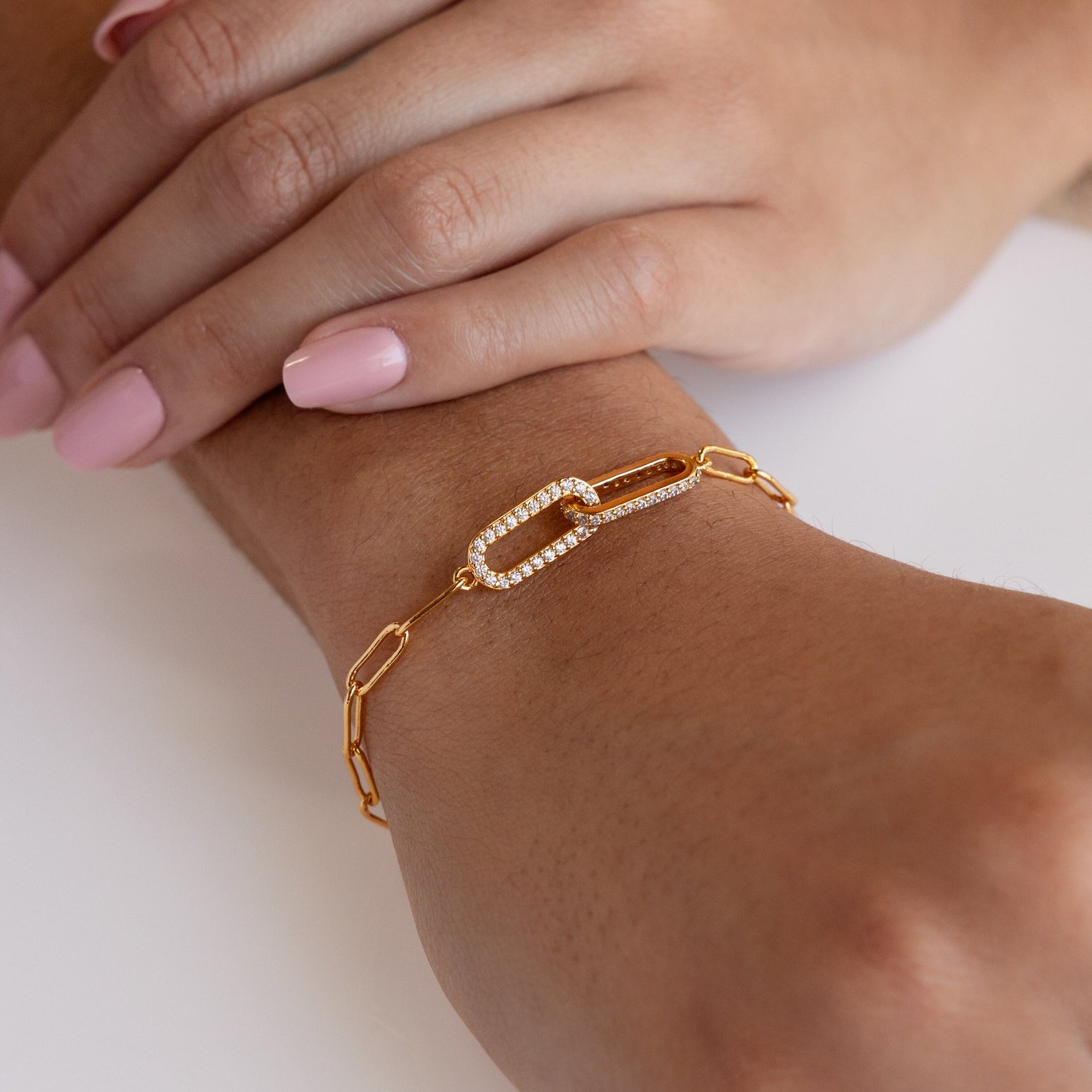 The Pave Link Chain Bracelet, featuring a diamond-encrusted paperclip design, is a true statement piece—perfect for pairing with light pink nail polish.
