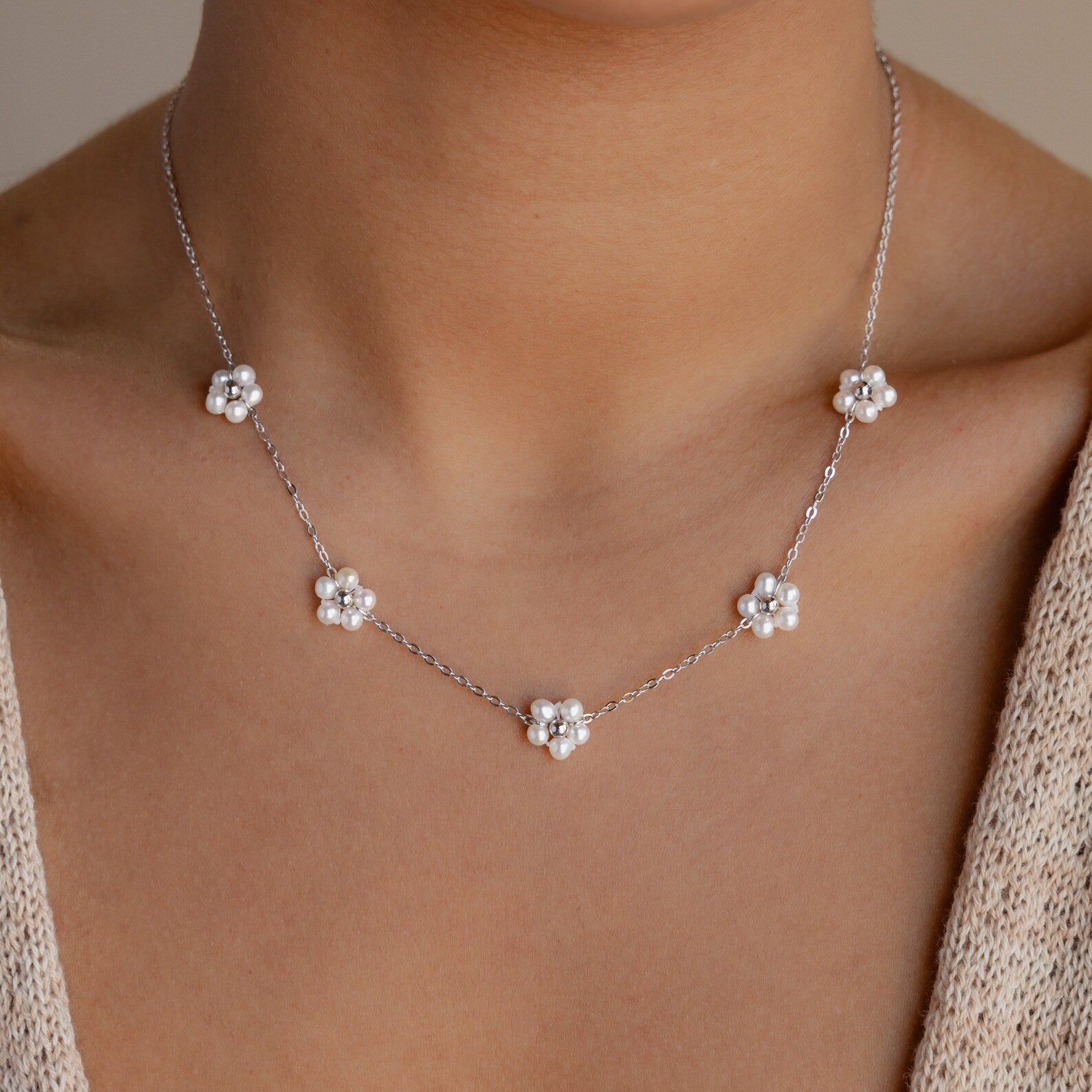 The Flower Pearl Station Necklace in Sterling Silver features five small white flower charms, making it an elegant choice for bridesmaids or a thoughtful Mother's Day gift.