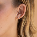 Close-up of a woman's ear wearing Baguette Chain Studs and a small clear diamond stud, perfect for a minimalist earring stack.