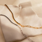 A stunning Black Diamond Tennis Bracelet, perfect as a statement accessory, is displayed on a soft, ivory satin fabric backdrop.