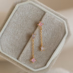 Mixed Crystal Drop Earrings with pink and clear stones, displayed on a beige fabric jewelry box—ideal for lovers of minimalist style.