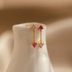 Mixed Pink Drop Earrings featuring pink and clear gemstones, shown on a glossy white ceramic stand.