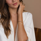 Woman in a white robe showcasing the Blue Diamond Tennis Bracelet on her wrist—a stunning minimalist accessory that elevates any occasion.