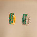 Two small hoop earrings, one gold and one silver, each with a green and blue marbled opal inlay, are shown on a beige background—perfect as Green Opal Inlay Hoops.