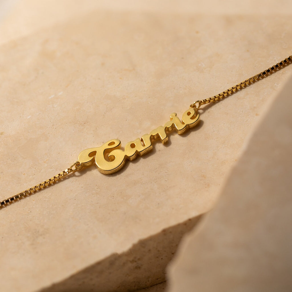 Groovy Name Necklace in Box Chain displayed on a neutral stone background—a stylish, customizable piece of jewelry with your chosen name in a trendy script.