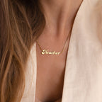 A person in a light beige top wears the Groovy Name Necklace in Box Chain, highlighting the elegance of custom jewelry.