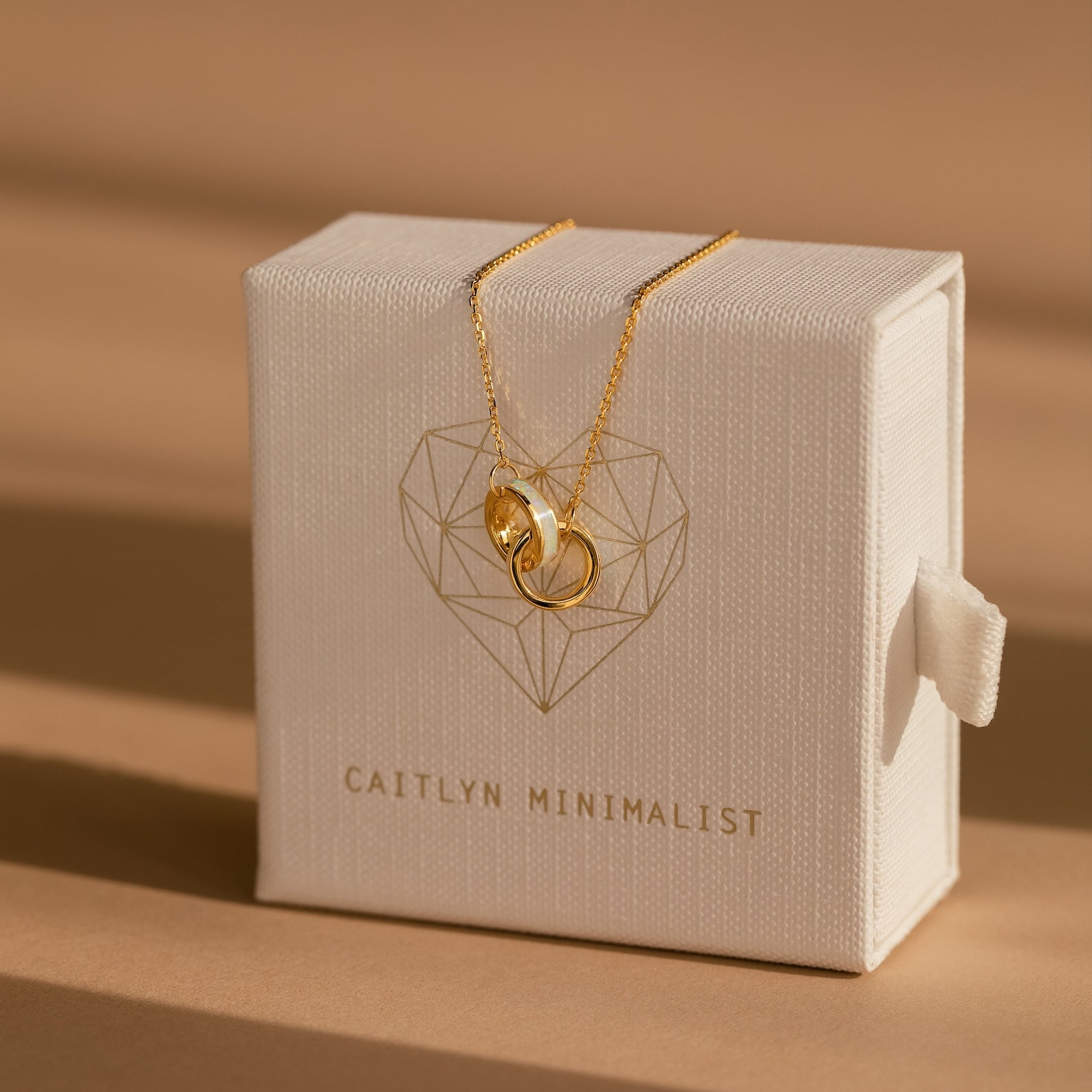 Interlocking Opal Inlay Bracelet showcased on a white jewelry box labeled “Caitlyn Minimalist”—ideal for minimalist jewelry lovers or pairing with a delicate necklace for an elegant touch.
