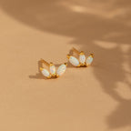 Dainty Opal Stud Earrings Set showcases three marquise-shaped opal stones in gold, displayed on a beige background with soft shadows—a stylish choice for any minimalist jewelry collection.