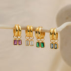 Four pairs of Dangling Emerald Birthstone Hoops with removable emerald-cut gemstones in purple, clear, green, and blue—perfect for a customizable birthstone look.