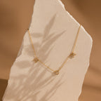 Pave Mom Necklace featuring three delicate pendants, displayed on a textured stone slab with soft shadow—a meaningful gift, perfect for moms.