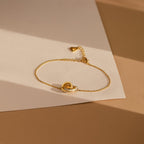 The Interlocking Opal Inlay Bracelet features a delicate design, ideal for minimalist jewelry lovers. Shown on textured white and beige paper in natural light.