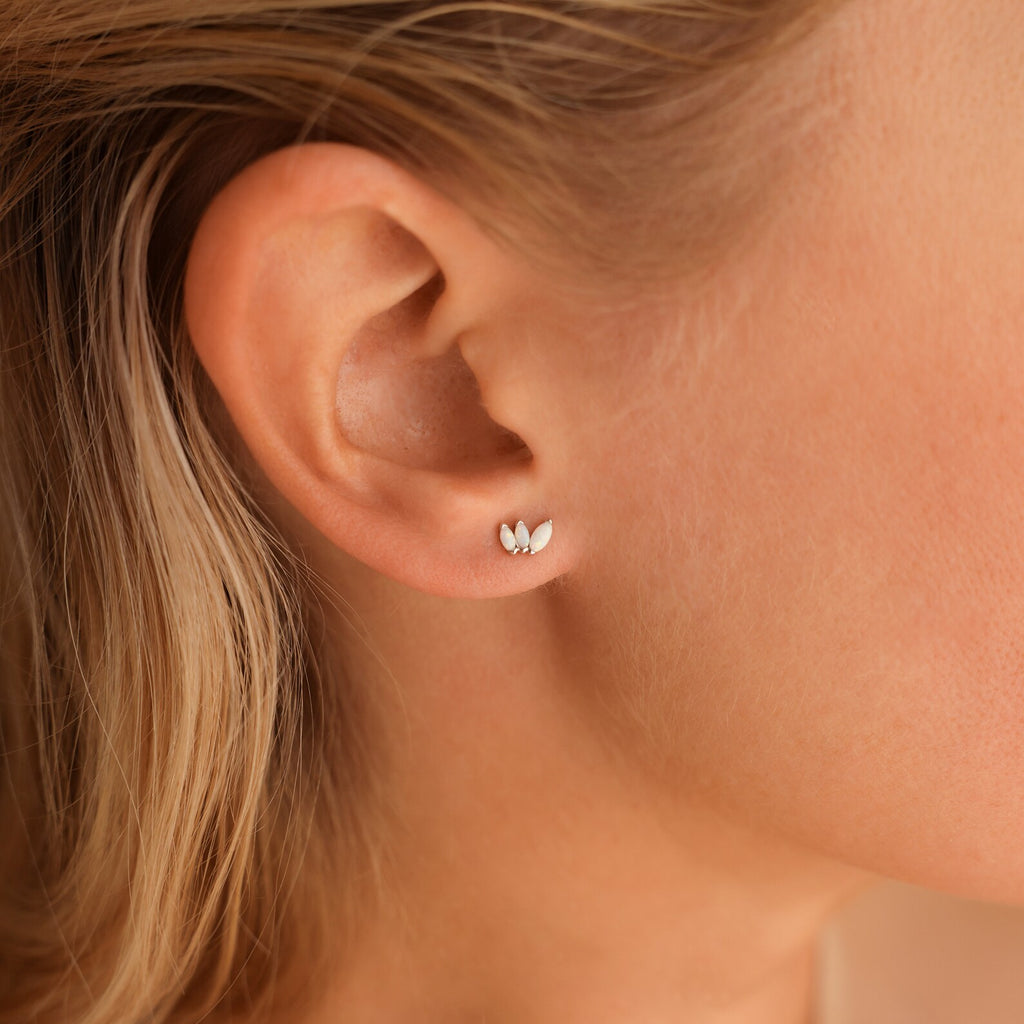 A close-up of a woman's ear adorned with Opal Marquise Studs, highlighting the delicate charm of these elegant earrings.