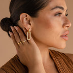 A woman wearing a gold ring and sparkling Pave Link Hoops.