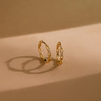 Diamond Link Hoops cast elegant shadows on a beige surface—a modern take on diamond chain link hoops, perfect as bridal or wedding earrings.