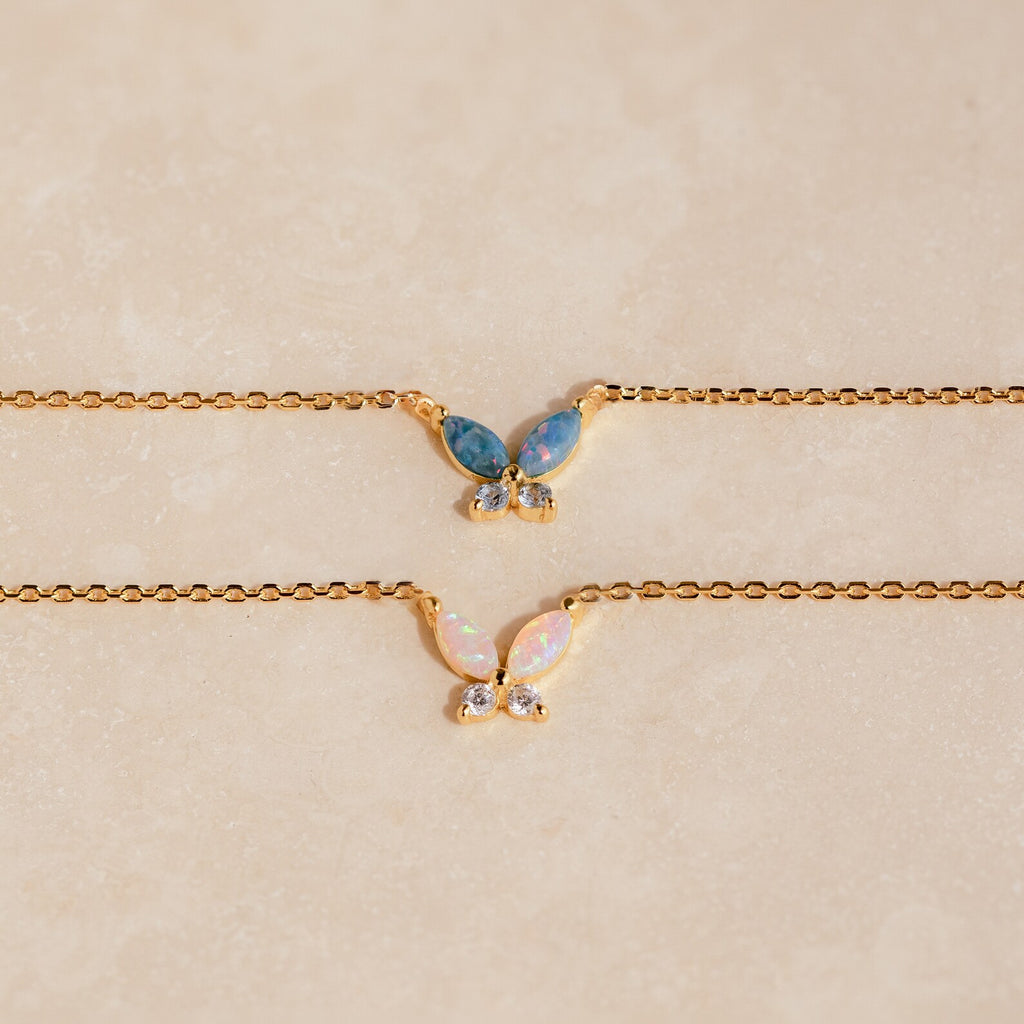 The Pink Opal Butterfly Necklace features a gold chain and a delicate butterfly pendant, adding a whimsical touch to any look. Perfect for layering with your favorite gemstone charm necklaces.