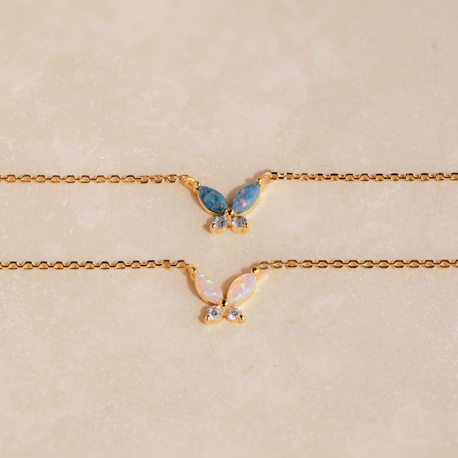 The Pink Opal Butterfly Necklace features a gold chain and a delicate butterfly pendant, adding a whimsical touch to any look. Perfect for layering with your favorite gemstone charm necklaces.