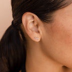 Close-up of a woman's ear adorned with three Tiny Diamond Climbers along the earlobe, hair tied back—an elegant choice perfect for anniversary gifting.