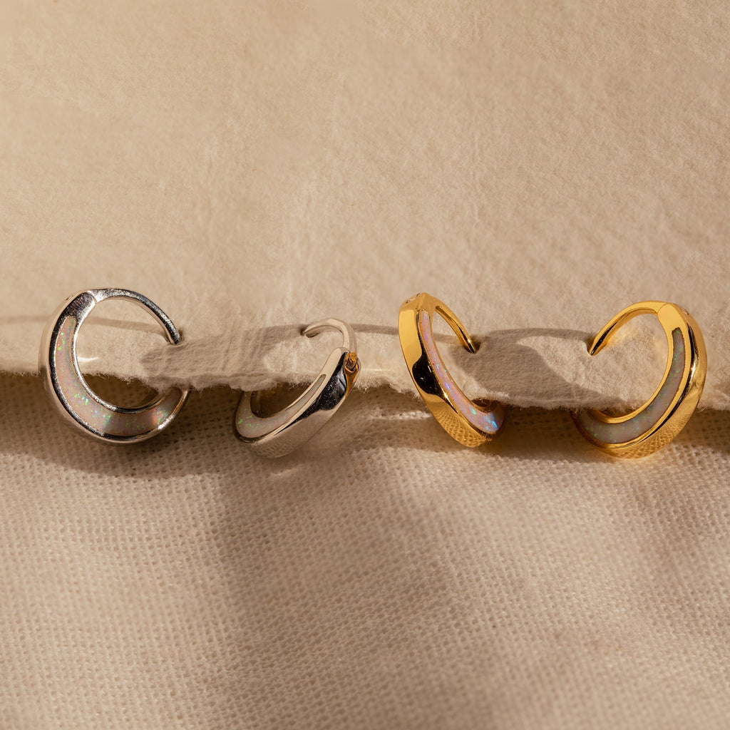 The Crescent Moon Opal Huggies are gold and silver hoop earrings perfect for stacking or wearing solo.