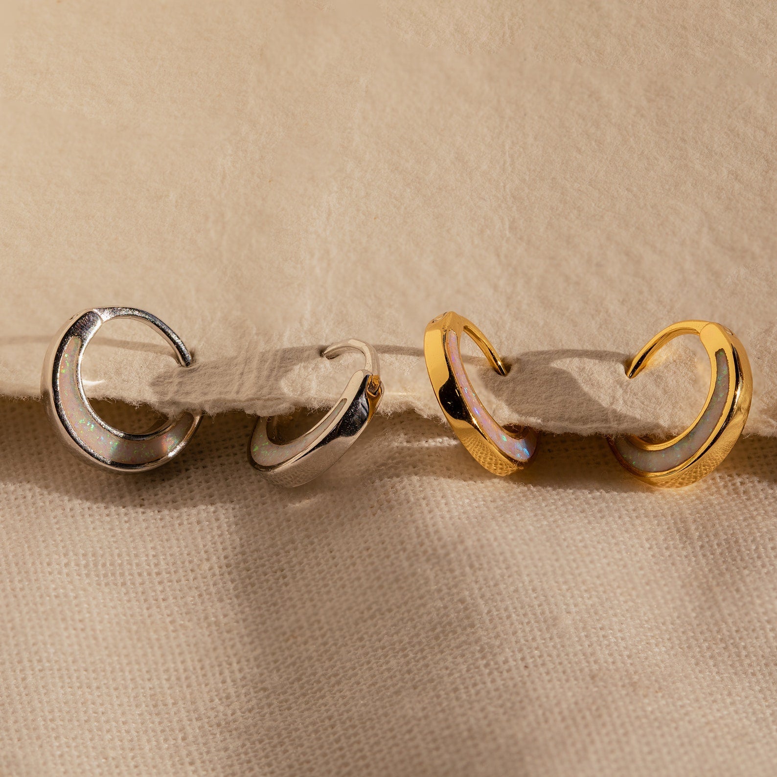 The Crescent Moon Opal Huggies are gold and silver hoop earrings perfect for stacking or wearing solo.