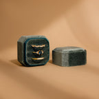 The Velvet Ring Box in green velvet features three slots for gold rings with gems, shown beside its matching lid on a tan background—a stylish jewelry gift box ideal for special occasions.