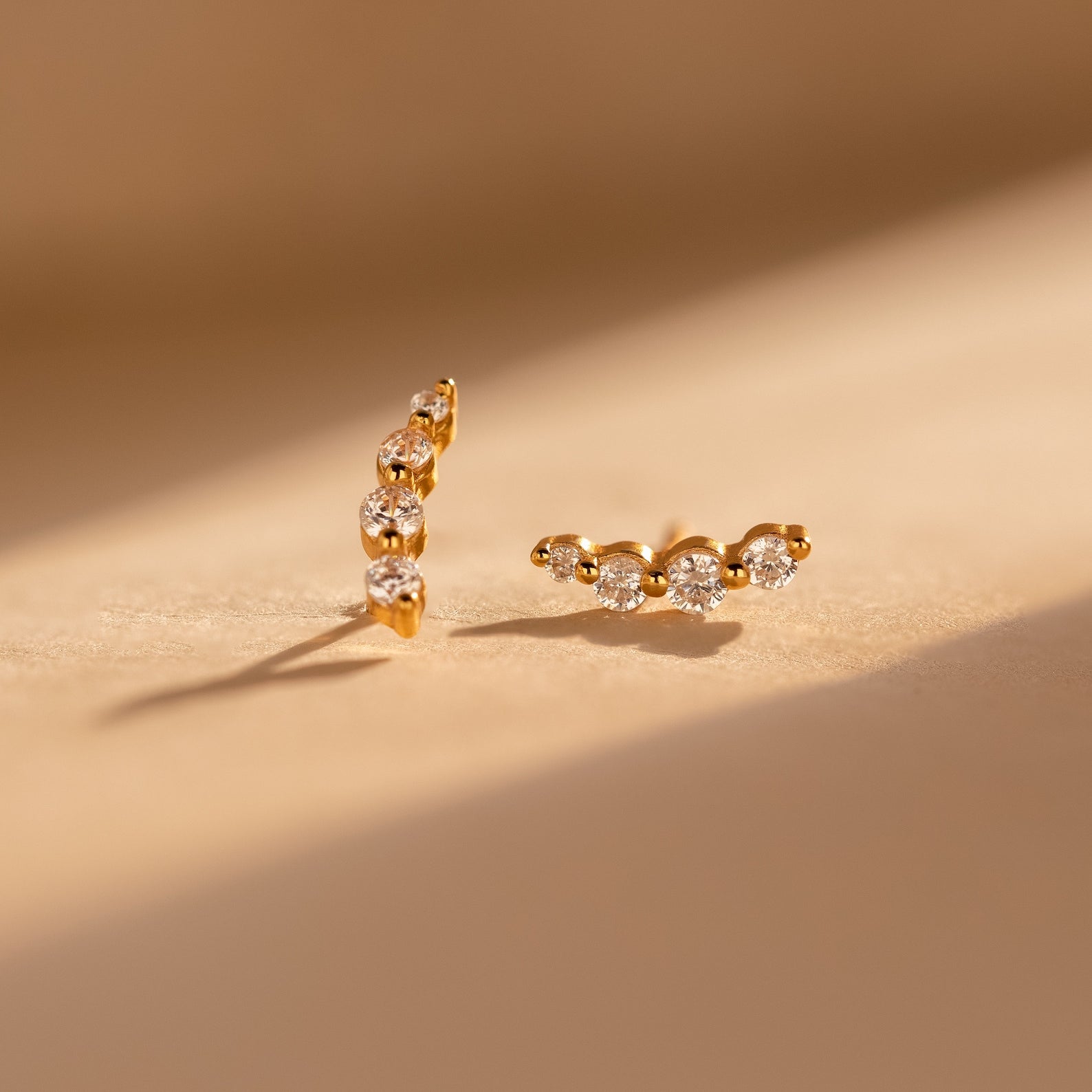 Tiny Diamond Climbers featuring three sparkling diamonds in each earring, displayed on a softly lit neutral surface—an ideal anniversary gift.