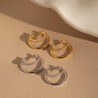 The Lydia Duo Cuffs feature two pairs of hoop earrings—one gold, one silver—with chain detail, ideal for layering with your favorite earrings or styling alongside a golden ear cuff for a chic look.
