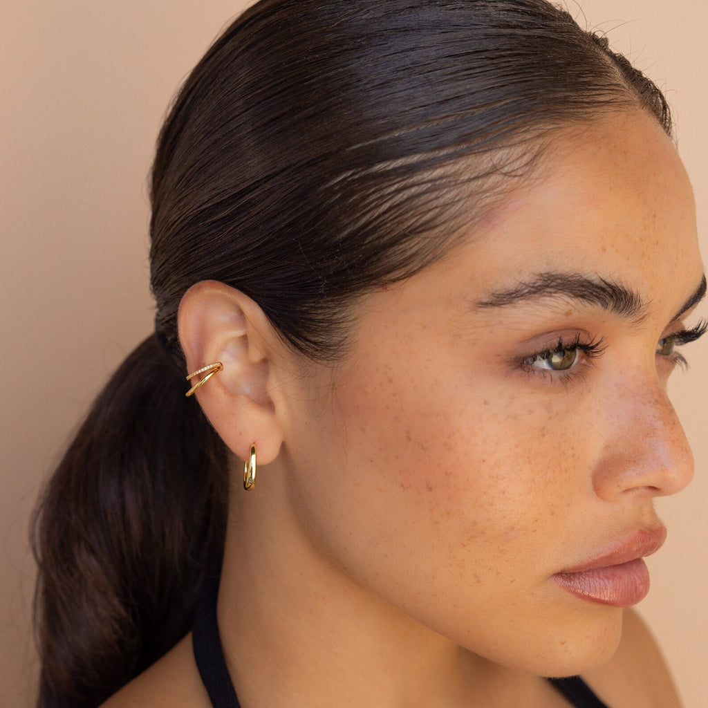 Woman with slicked-back hair wearing Lydia Duo Cuffs, looking to the side against a beige background.