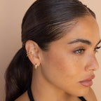 Woman with slicked-back hair wearing Lydia Duo Cuffs, looking to the side against a beige background.