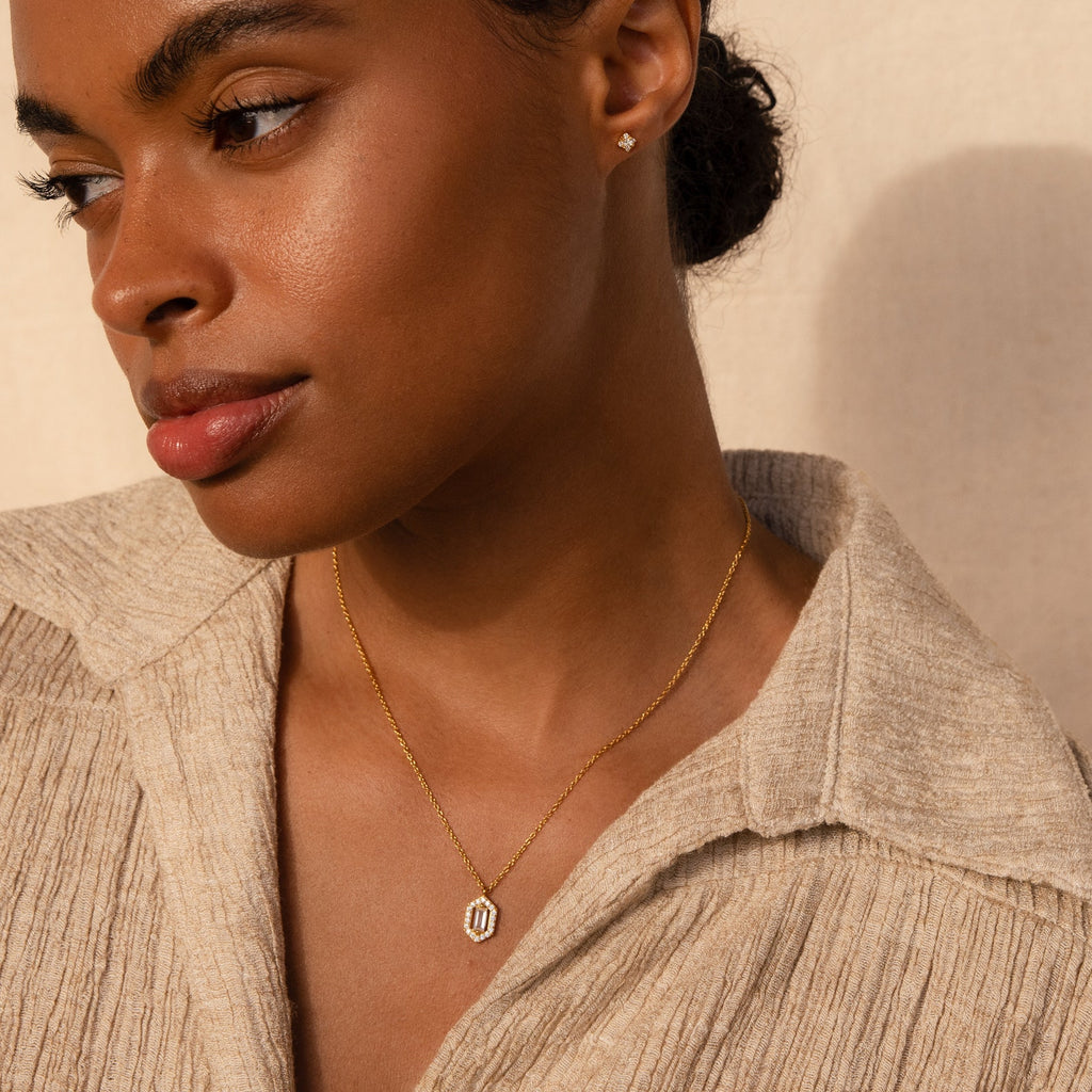 Woman exudes timeless elegance in a beige textured shirt, wearing the Daydreamer Diamond Necklace and stud earrings, gazing thoughtfully to the side.