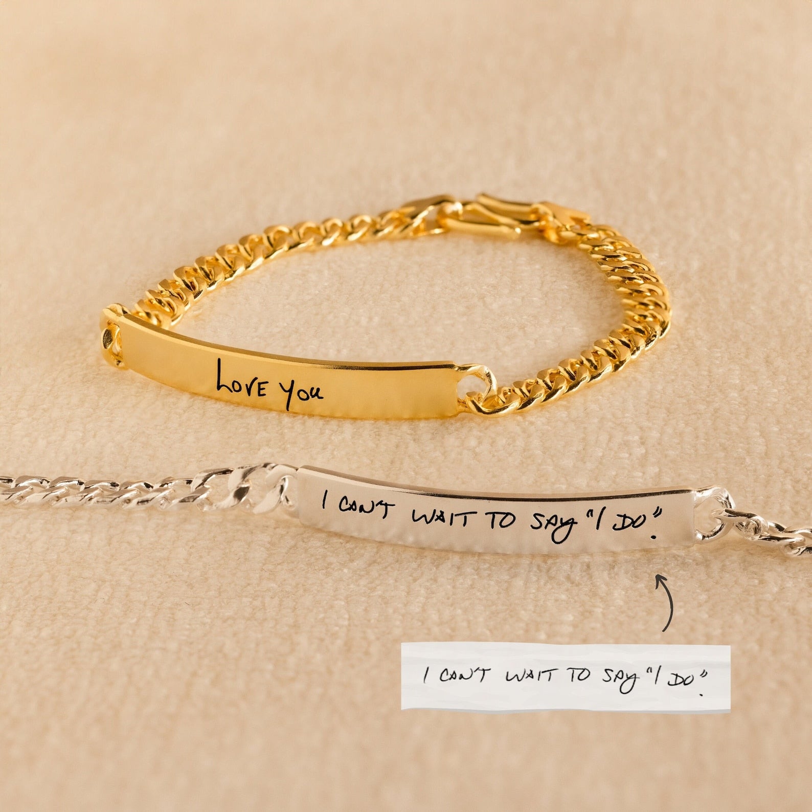 A Men's Engraved Bar Bracelet rests on a beige surface—one gold reads Love you, another in silver says I can't wait to say I do. These personalized bracelets make meaningful memorial gifts or unforgettable keepsakes.