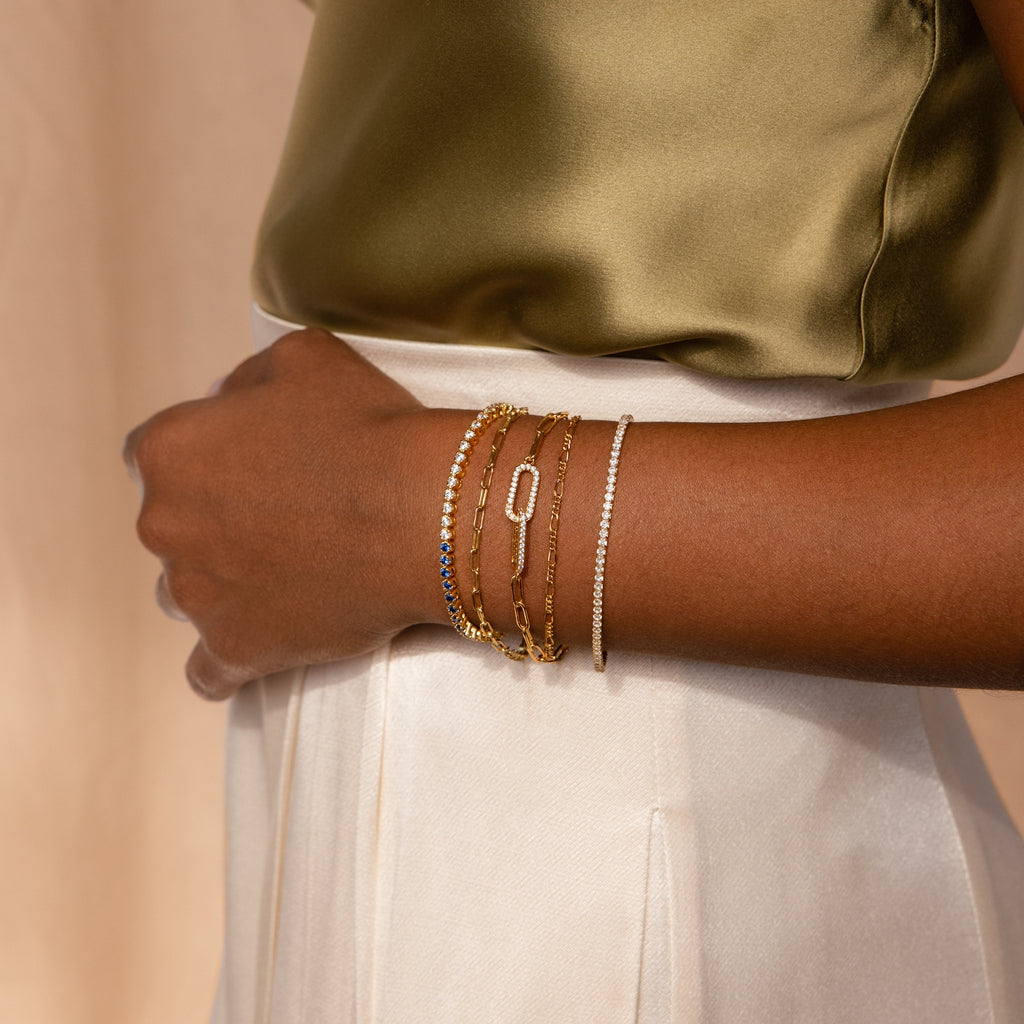 A person wearing the Must-Have Bracelet Chains, paired with a satin olive top and cream high-waisted pants.