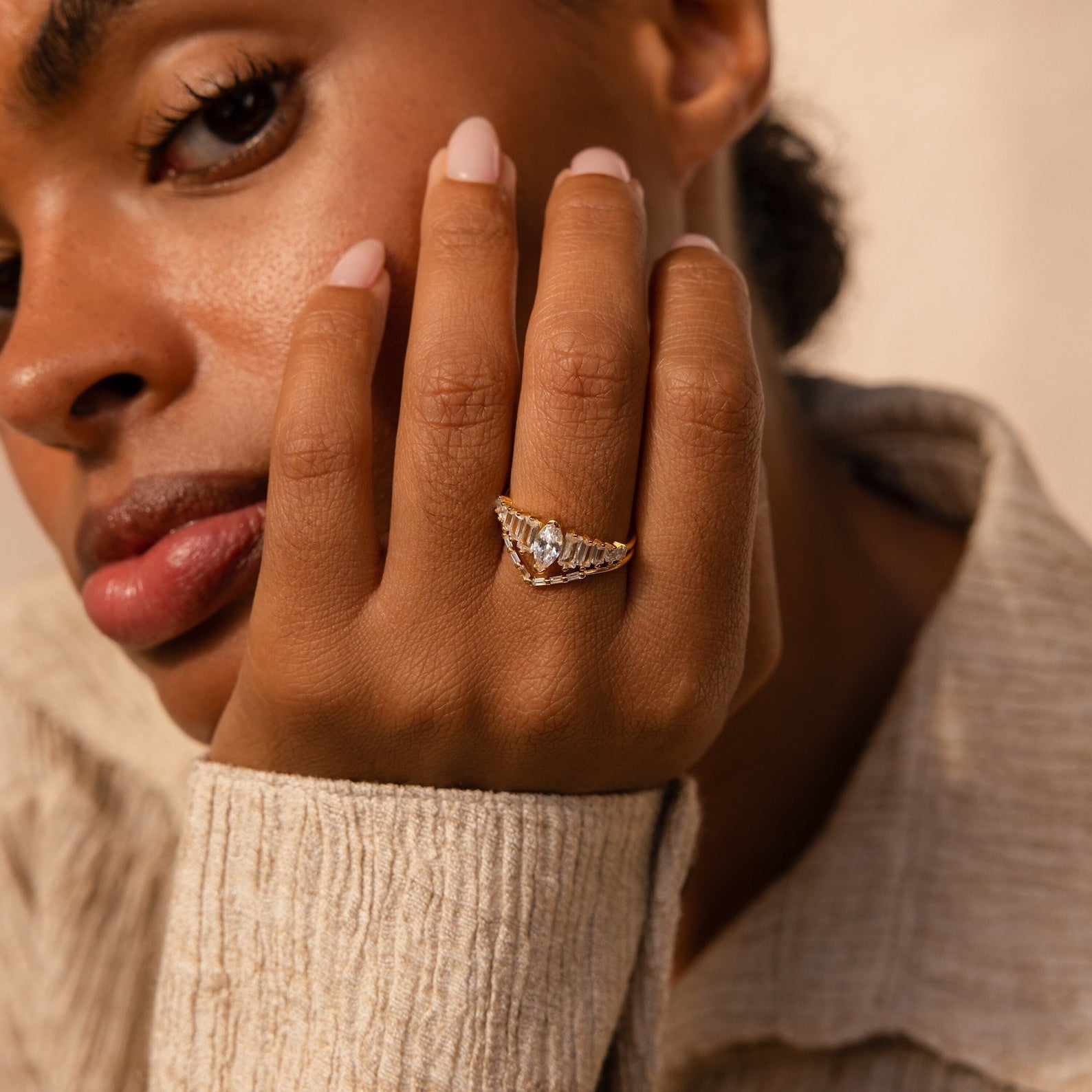 A woman wears the Art Deco Ring Set with multiple diamonds, resting her hand on her face and looking at the camera.