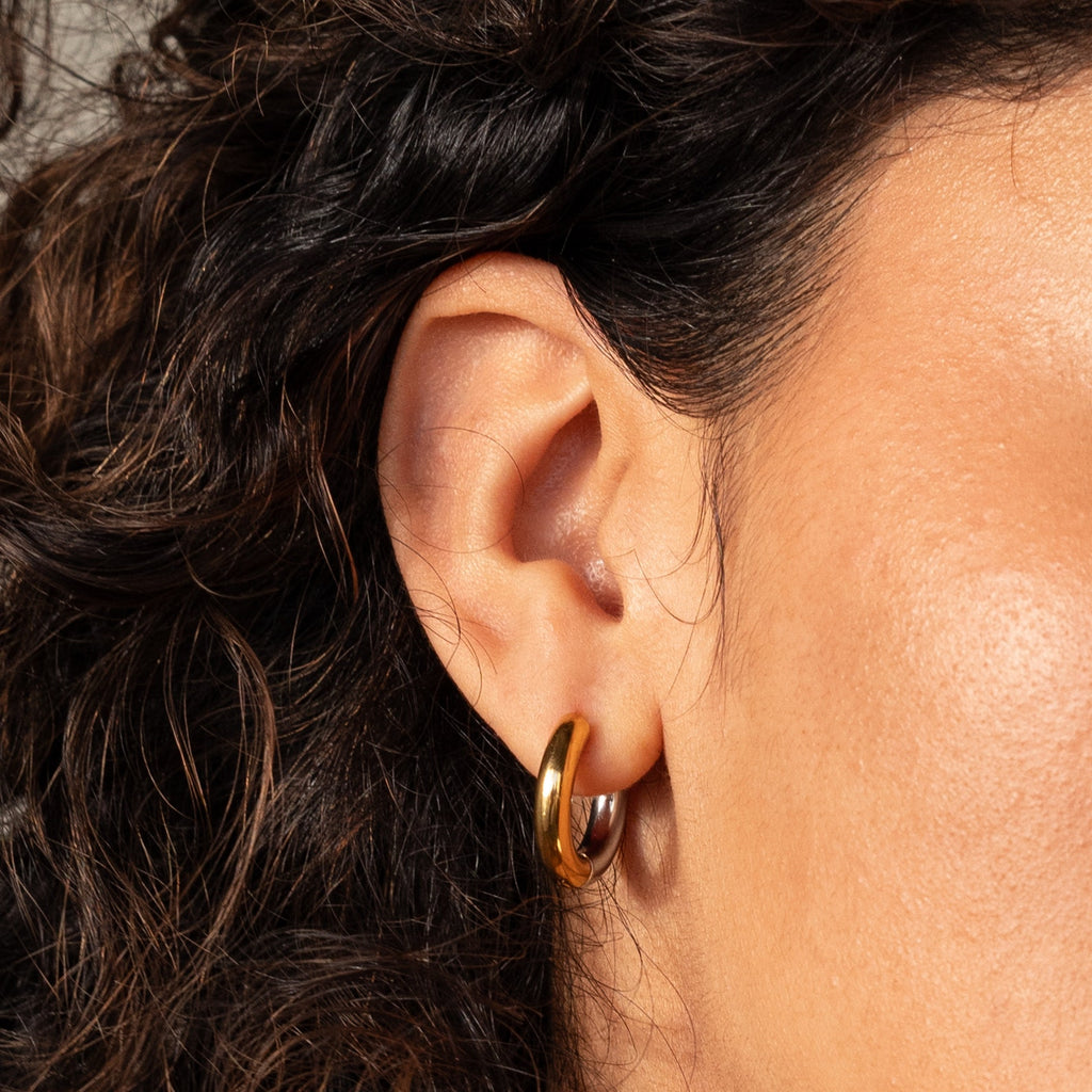 A close-up of a woman's ear adorned with Chunky Hoops earrings.