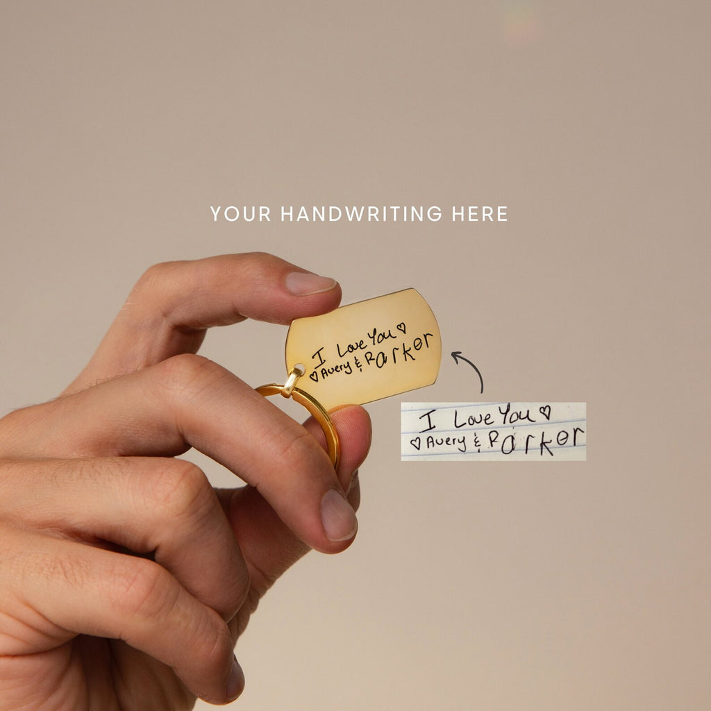 A hand holds a Handwriting Dog Tag Keychain, engraved with the heartfelt message “I love you Avery & Parker,” making it the perfect Father’s Day gift.