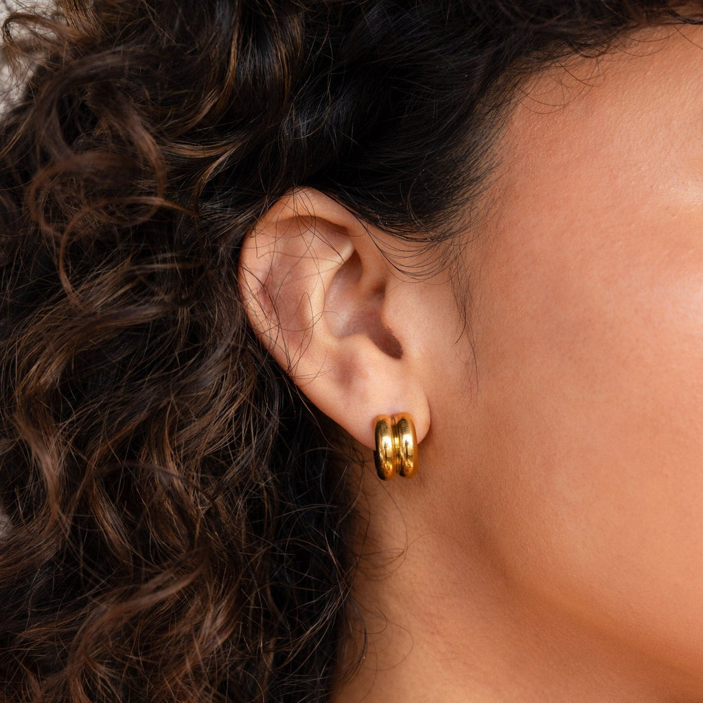 A close-up of a woman's ear wearing the Chunky Double Hoops, a bold statement accessory.