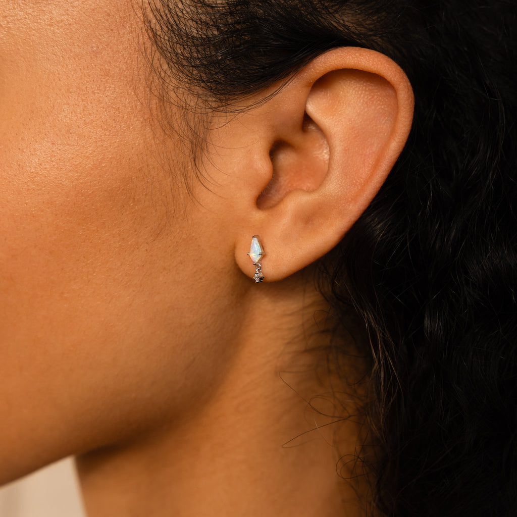 Close-up of a woman's ear wearing Art Deco Drop Studs, featuring small, delicate design with opal and CZ Diamond accents.