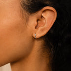 Close-up of a woman's ear wearing Art Deco Drop Studs, featuring small, delicate design with opal and CZ Diamond accents.