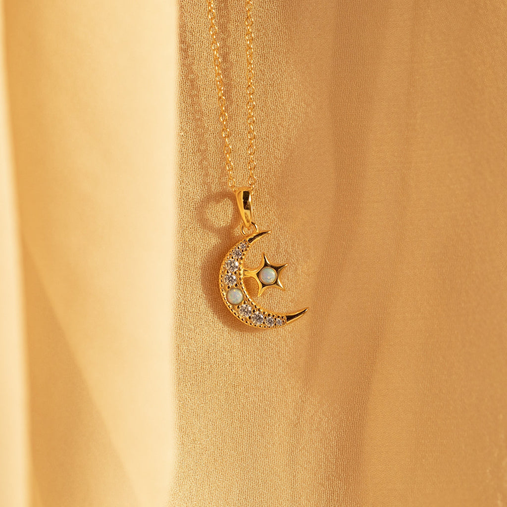 Opal Moon & Star Necklace featuring a crescent moon and star pendant with small gemstones, showcased on soft beige fabric.