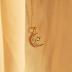 Opal Moon & Star Necklace featuring a crescent moon and star pendant with small gemstones, showcased on soft beige fabric.
