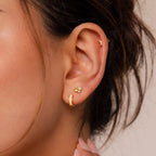 Close-up of a woman's ear adorned with the Opal Inlay Earrings Set: a gold hoop, a three-stone opal inlay stud, and a tiny crescent on the helix—an elegant jewelry set gift for her.